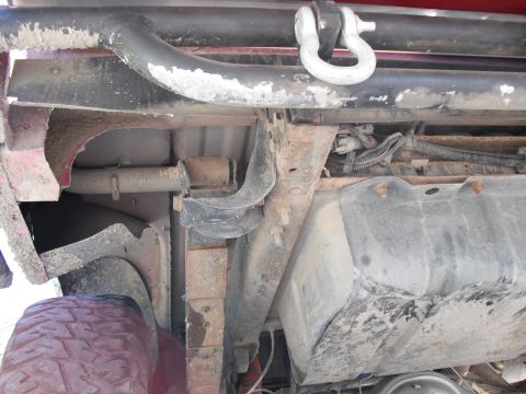 1991 Ford Bronco - Close-up of the undercarriage, revealing suspension parts and a fuel tank.