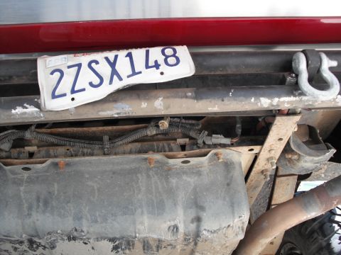 1991 Ford Bronco - Underside view of a vehicle's rear bumper, showing a license plate and a tow hook attachment.