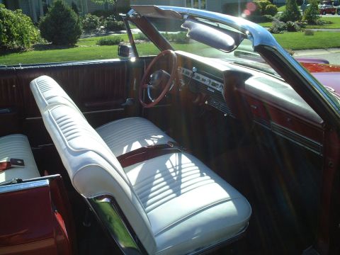 1967 Ford Galaxie - Interior view of a 1967 Ford Galaxie convertible, its white seats and wood-grain dashboard details.