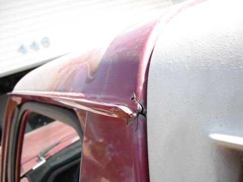 1991 Ford Bronco - Close-up of the damaged cab corner of a red and white truck.