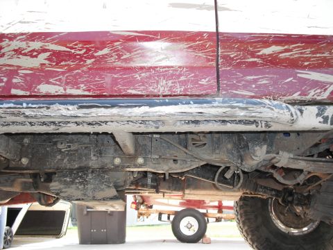 1991 Ford Bronco - Undercarriage view of a mud-covered vehicle, revealing suspension and frame details.
