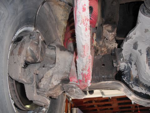 1991 Ford Bronco - Underside view of a vehicle's front suspension system, including brake components and shock absorber.