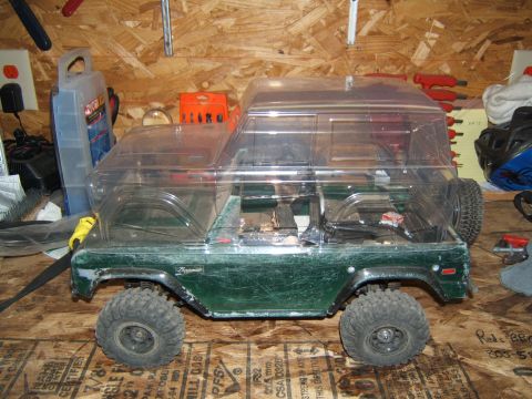 1988 Ford Bronco - RC crawler model of a Ford Bronco, likely a 1978 model, on a workbench with tools in the background.
