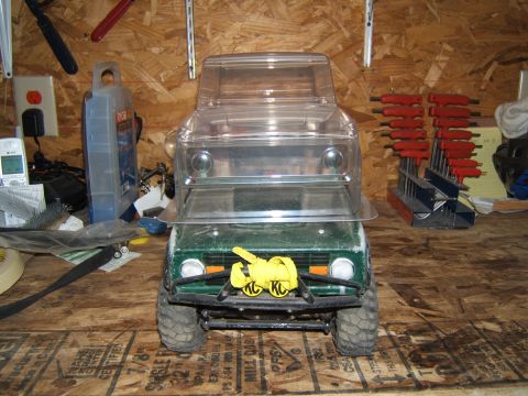 1988 Ford Bronco - A remote-controlled truck sits on a workbench in a garage, surrounded by tools and supplies.
