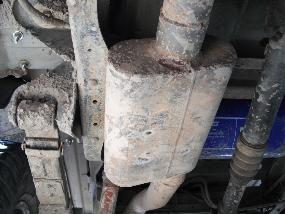Underside view of a vehicle's exhaust system with a blue filter visible