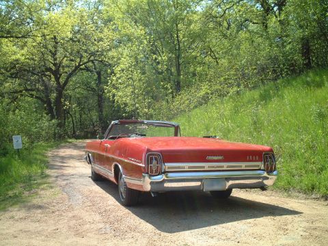 1967 Ford Galaxie - Rear view of a red 1967 Ford Galaxie convertible on a dirt road.