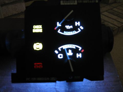 1996 Ford F-150 - This instrument cluster displays illuminated gauges and warning lights, including the check engine and brake indicators.