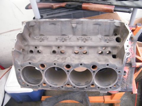 1982 Ford Bronco - A V8 engine block is shown from the front, resting on an orange engine stand.