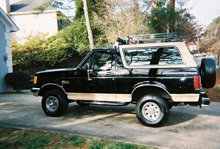 1990 Ford Bronco - Side view of a 1990 Ford Bronco with a two-tone paint scheme and external storage.