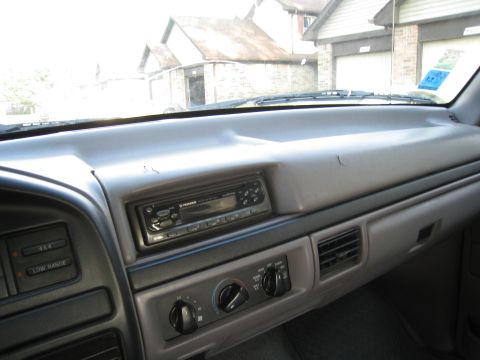 1996 Ford Bronco - The dashboard of a vehicle shows a Pioneer stereo and climate controls, with houses and garages visible outside.