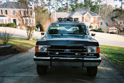 1990 Ford Bronco - This Ford Bronco is parked in a driveway in front of a large house. It has a 'For Sale' sign in the windshield.