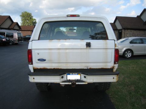 1996 Ford Bronco - Rear view of a white 1996 Ford Bronco, showing rust stains on the tailgate and a visible Ford badge.