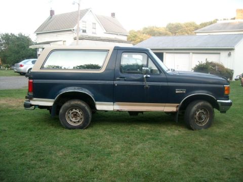 1987 Ford Bronco - Side view of a 1987 Ford Bronco parked on a grassy lawn.