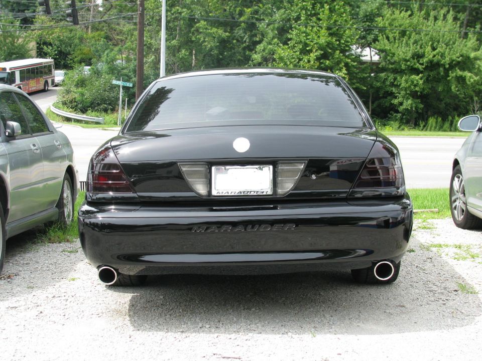 Black sedan rear view, dual exhaust pipes, tinted taillights, 'Marauder' badge visible