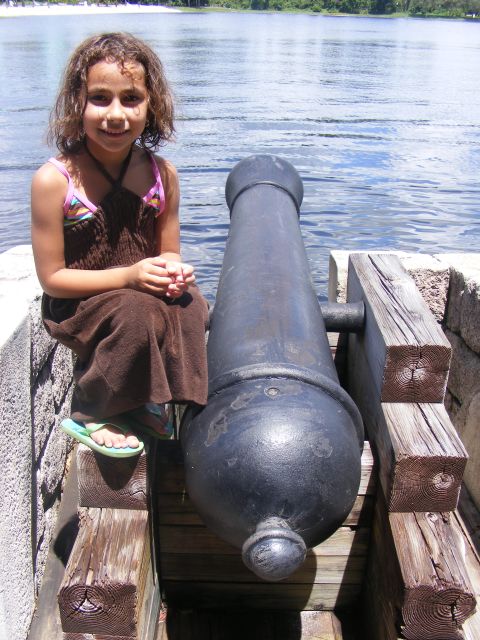 2008 Jeep Cherokee - A young girl poses with a historic cannon near a body of water on a sunny day.
