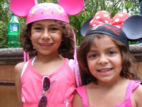 2008 Jeep Cherokee - Two smiling girls wearing pink outfits and Minnie Mouse ears pose for a photo, with a green bottle visible in the background.