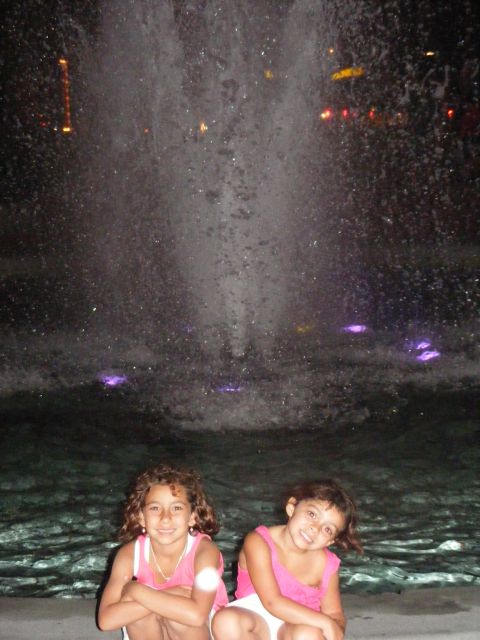 2008 Jeep Cherokee - Two girls pose in front of a fountain at night, illuminated by purple lights.