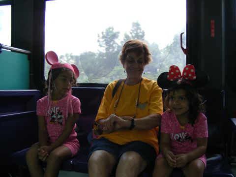 2008 Jeep Cherokee - A woman and two young girls, all wearing Disney-themed mouse ears, are seated together on a bench inside a vehicle.