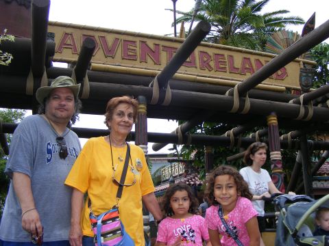 2008 Jeep Cherokee - A family stands together under the Adventureland sign, smiling for a photo.