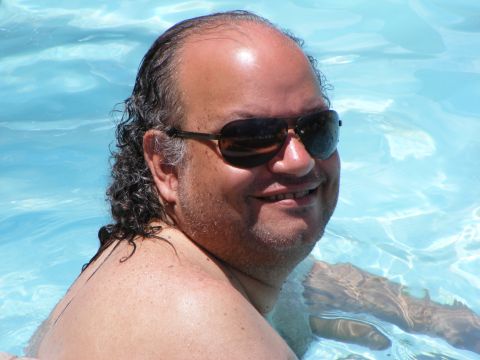 2008 Jeep Cherokee - Man wearing sunglasses relaxes in a bright blue swimming pool.