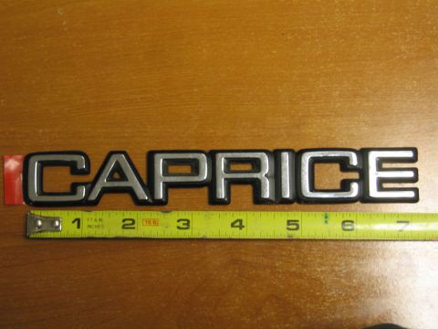 1991 Ford LTD Crown Victoria - A chrome 'Caprice' emblem is shown with a tape measure for scale.