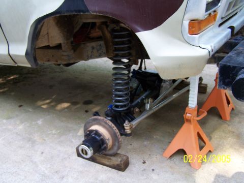 1979 Ford F-150 - Front suspension and wheel hub assembly of a 1979 Ford F-150, supported by jack stands.