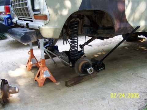 1979 Ford F-150 - Front suspension of a 1979 Ford F-150 undergoing repairs, supported by jack stands.