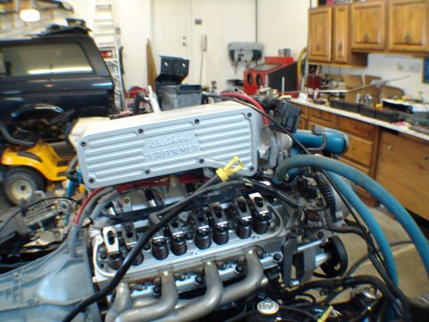 1996 Ford Bronco - Close-up of an engine an Edelbrock Performer valve cover and exhaust manifold, likely undergoing maintenance or rebuild.