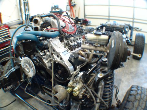 1996 Ford Bronco - Engine assembly in a garage, possibly undergoing repair or rebuild.