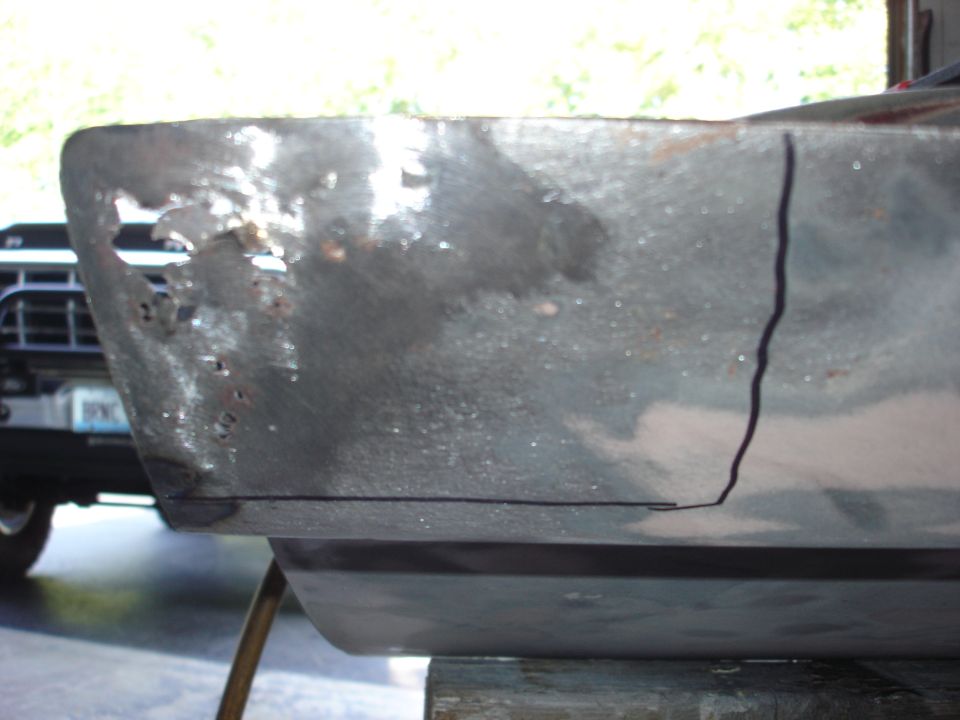 Rusted metal panel with cut lines, blurred truck grille in background