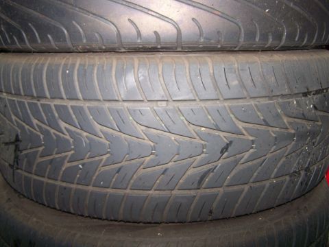 1997 Mitsubishi Eclipse - Close-up view of the tread pattern on a stack of used tires.