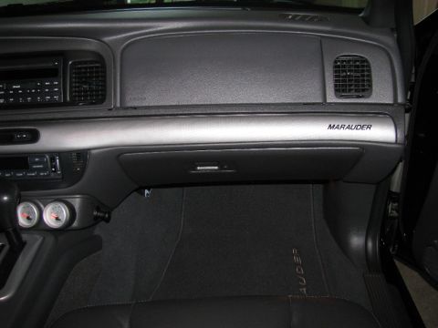 2003 Mercury Marauder - The dashboard of a 2003 Mercury Marauder, the 'Marauder' nameplate on the trim above the glove compartment.