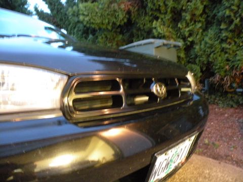 1998 Subaru Legacy - Close-up of the front grille and headlight of a 1998 Subaru Legacy.