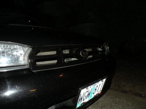 1998 Subaru Legacy - Front view of a black 1998 Subaru Legacy, showing the grille and headlight with a visible license plate.