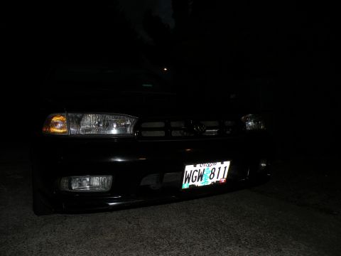 1998 Subaru Legacy - The front grille and headlights of a 1998 Subaru Legacy are visible at night.