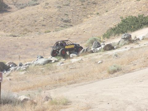 1995 Ford Bronco - Custom buggy navigates a challenging rocky trail in a dry, hilly landscape.
