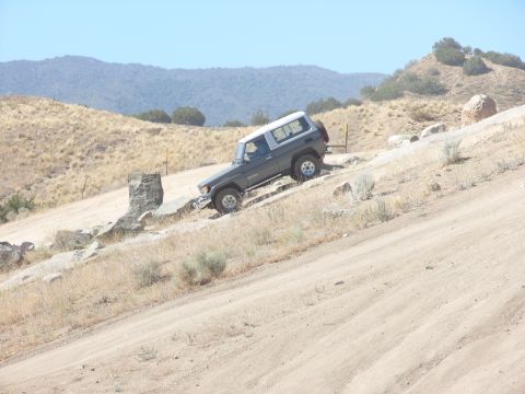 1995 Ford Bronco - This SUV is navigating a challenging off-road terrain with rocky obstacles.