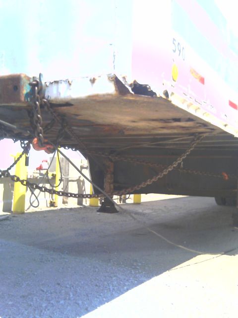 1992 Ford Bronco - Trailer chassis with chains and safety posts, viewed from below.