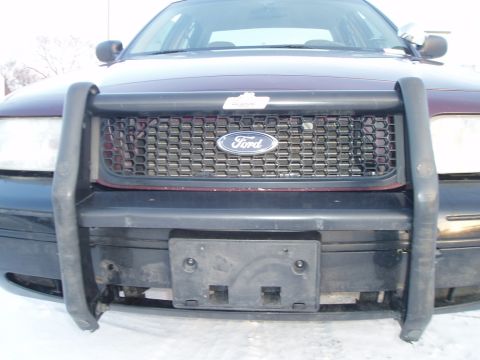1999 Ford Crown Victoria - This Ford Crown Victoria has a push bar and a black honeycomb grille. The license plate mount is visible.