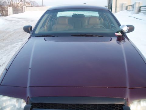 1999 Ford Crown Victoria - Front view of a purple sedan with a tan interior, parked in a snowy environment.