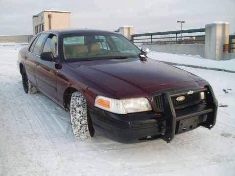 1999 Ford Crown Victoria - This maroon 1999 Ford Crown Victoria is parked on a snowy surface, equipped with a front push bar.