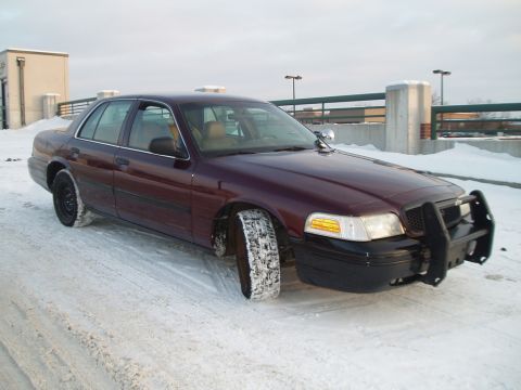 1999 Ford Crown Victoria - Maroon Ford Crown Victoria with a push bar in a snowy environment. The vehicle appears to be a later model.