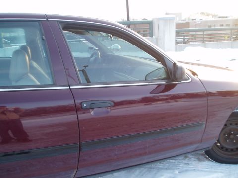 1999 Ford Crown Victoria - A maroon sedan is parked outside in the snow, with a view of its side door and interior.