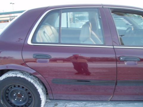 1999 Ford Crown Victoria - Side view of a purple sedan with a reflection of the photographer in the door.