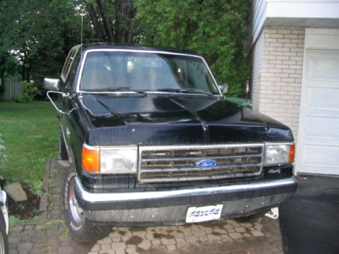 1986 Ford Bronco - This black 1986 Ford Bronco features a prominent chrome grille with the iconic Ford emblem and a 4x4 badge.