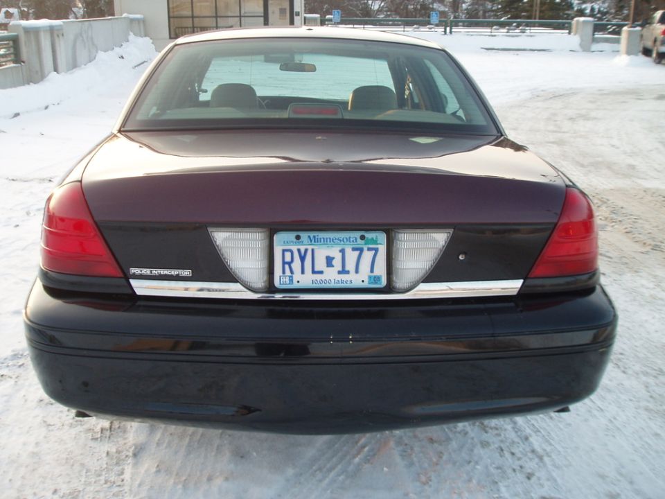 Dark purple and black Ford Crown Victoria Police Interceptor rear view, Minnesota license plate RYL-177