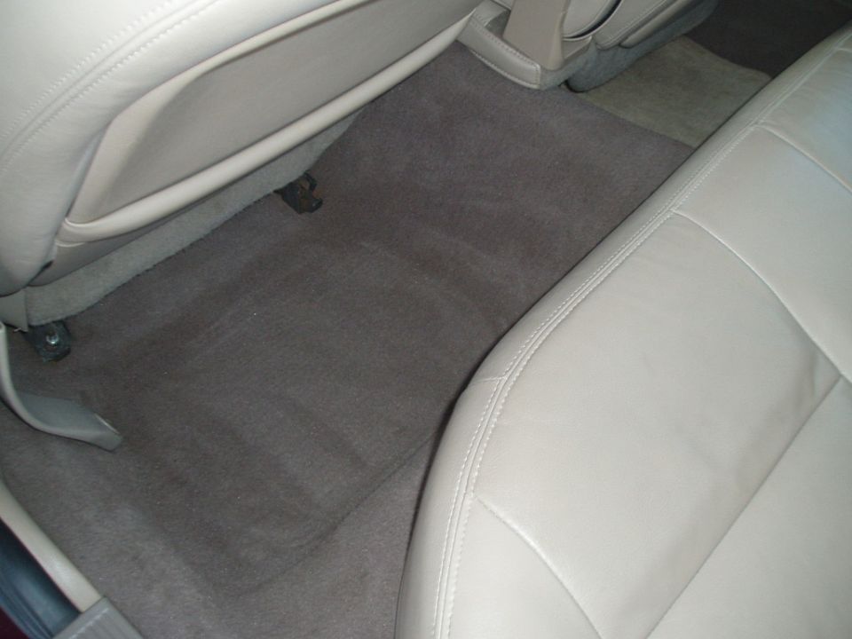 Car interior with tan leather seats and gray carpeted floor. Watermark 'SUPERMOTORS www.supermotors.net' visible