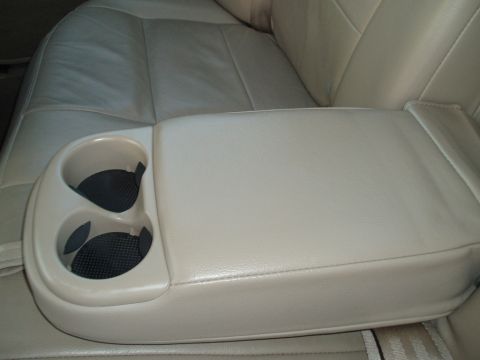 1999 Ford Crown Victoria - Interior view of a car's center console armrest and cup holders.