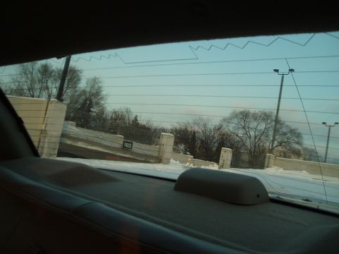 1999 Ford Crown Victoria - Looking out the back window at a winter scene with snow on the ground and bare trees.