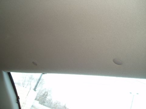 1999 Ford Crown Victoria - Interior view of a car's headliner shows speaker grilles and a stain.